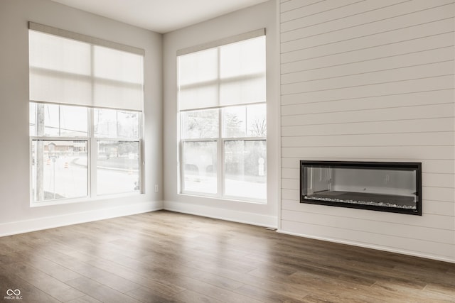401 Jersey St, Westfield, IN 46074 - unfurnished living room featuring baseboards, a glass covered fireplace, and wood finished floors