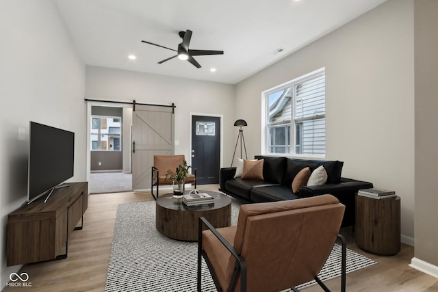 202 Mckim Ave, Indianapolis, IN 46201 - living area featuring light wood finished floors, a barn door, a ceiling fan, and a healthy amount of sunlight