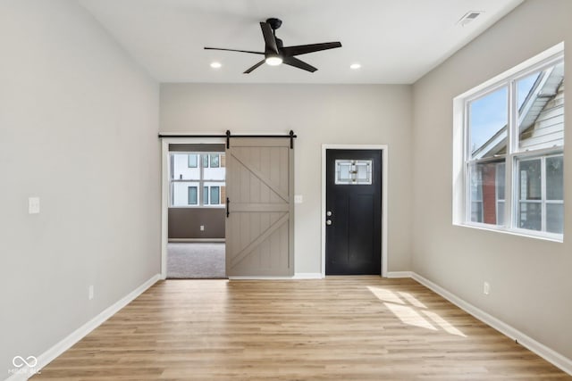 202 Mckim Ave, Indianapolis, IN 46201 - foyer featuring light wood-style flooring, a barn door, baseboards, and a healthy amount of sunlight
