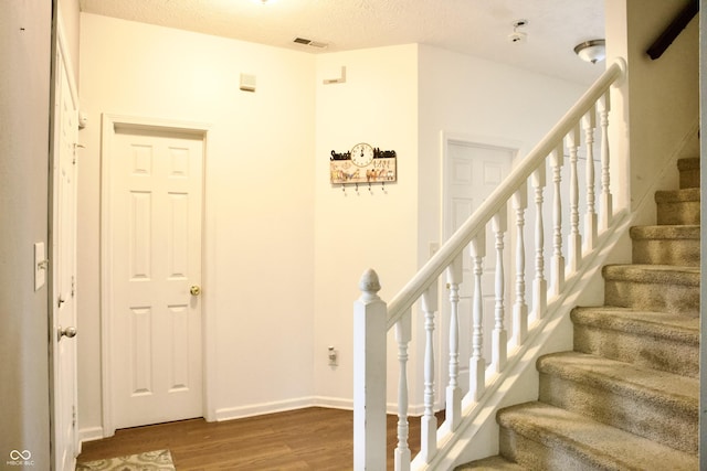 1831 Brook Crossing Way, Indianapolis, IN 46229 - stairs with a textured ceiling, baseboards, wood finished floors, and visible vents