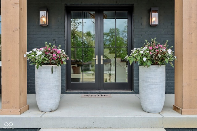 11064 Hamilton Run, Zionsville, IN 46077 - view of exterior entry with french doors, brick siding, and a porch
