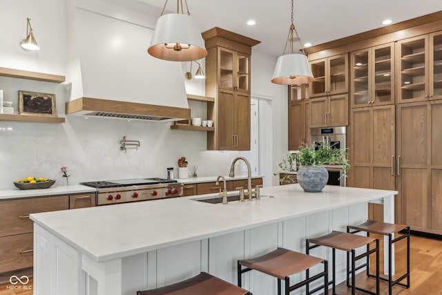 11064 Hamilton Run, Zionsville, IN 46077 - kitchen with custom range hood, a sink, brown cabinetry, decorative backsplash, and light countertops