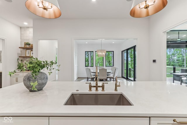 11064 Hamilton Run, Zionsville, IN 46077 - kitchen featuring light countertops, recessed lighting, decorative light fixtures, a sink, and white cabinetry