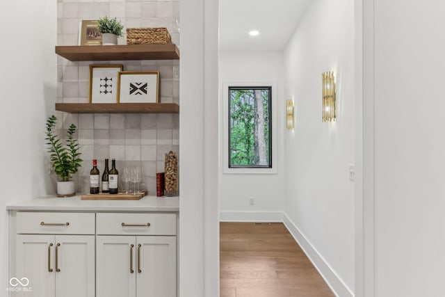 11064 Hamilton Run, Zionsville, IN 46077 - indoor dry bar featuring wood finished floors, decorative backsplash, baseboards, and recessed lighting