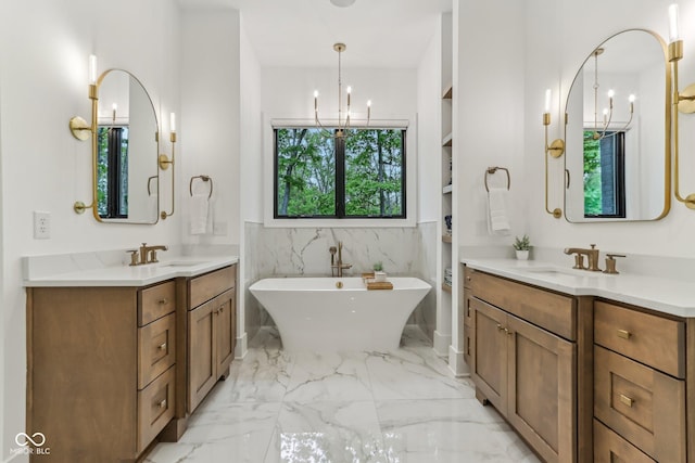 11064 Hamilton Run, Zionsville, IN 46077 - full bathroom featuring a chandelier, marble finish floors, a soaking tub, built in shelves, and two vanities