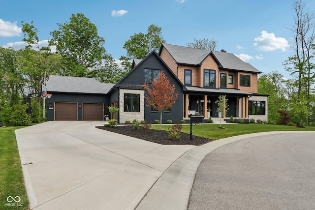 11064 Hamilton Run, Zionsville, IN 46077 - view of front facade featuring a garage, concrete driveway, a front lawn, covered porch, and stone siding