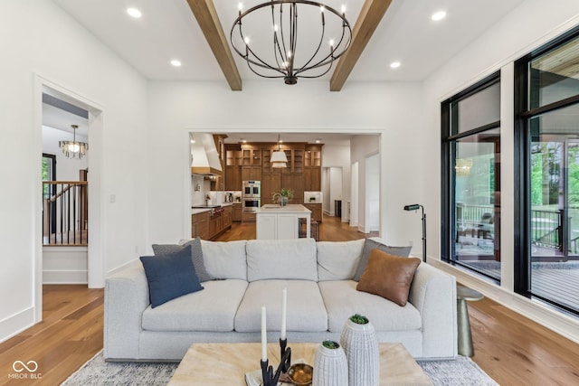 11064 Hamilton Run, Zionsville, IN 46077 - living room featuring a chandelier, plenty of natural light, beamed ceiling, light wood-style flooring, and baseboards