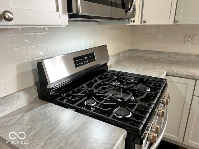 details with light countertops, gas stove, decorative backsplash, and white cabinets