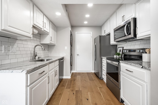 2823 Somerset Bay, Indianapolis, IN 46240 - kitchen featuring appliances with stainless steel finishes, white cabinets, backsplash, light wood finished floors, and recessed lighting
