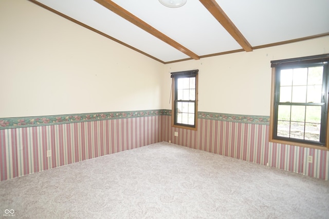 carpeted spare room featuring vaulted ceiling with beams
