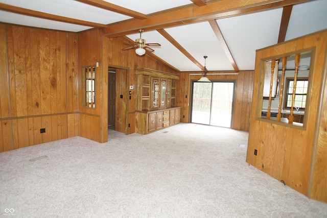 interior space with vaulted ceiling with beams, wood walls, and a ceiling fan