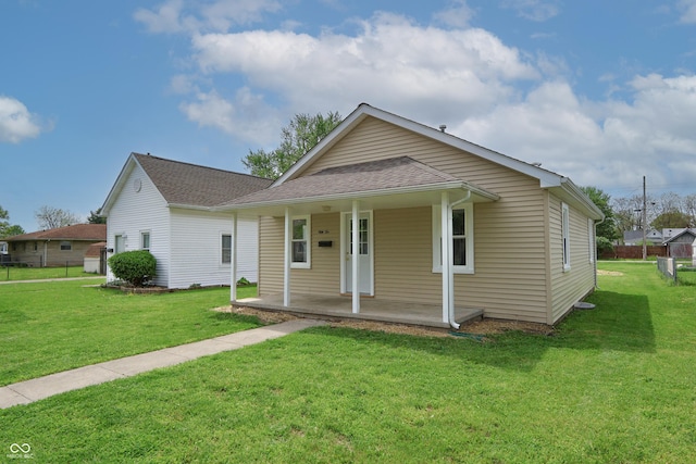 bungalow-style house with covered porch, a shingled roof, and a front yard