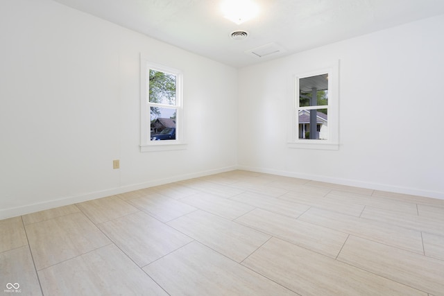 spare room featuring baseboards and visible vents