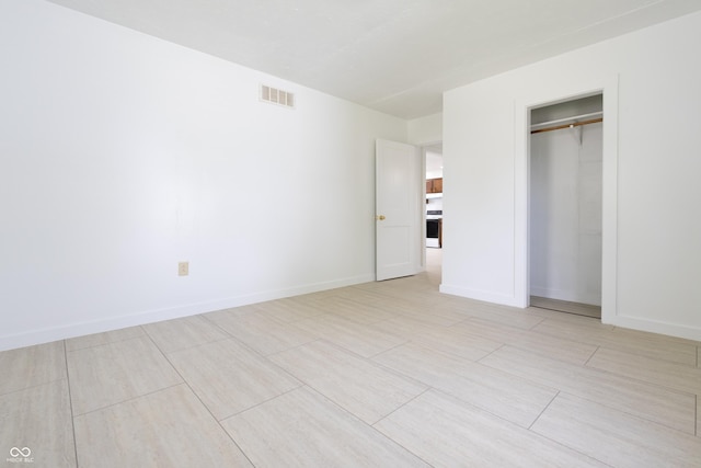 unfurnished bedroom with baseboards, visible vents, and a closet