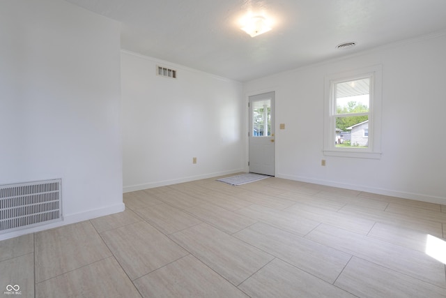 empty room featuring visible vents and ornamental molding