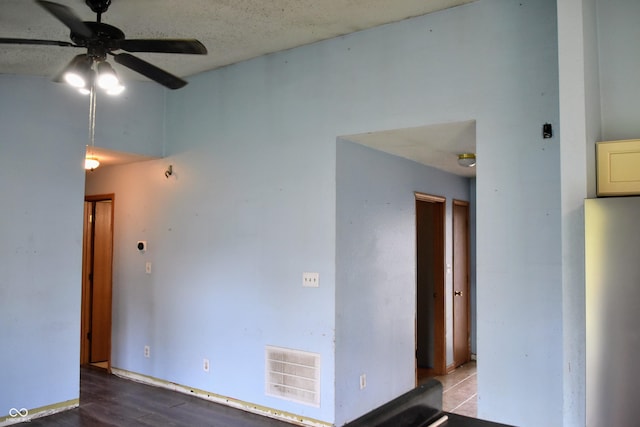 empty room featuring visible vents, ceiling fan, and wood finished floors