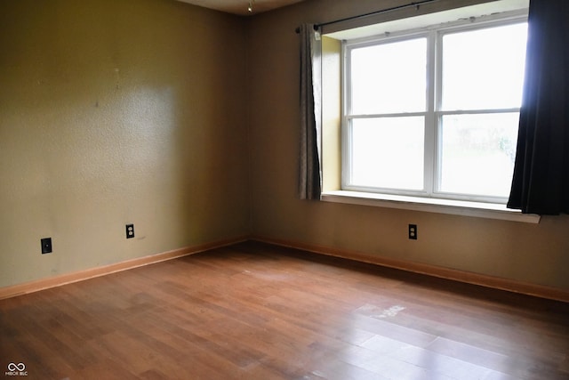 empty room featuring baseboards and wood finished floors