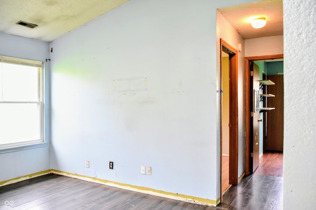 spare room featuring baseboards, visible vents, and wood finished floors