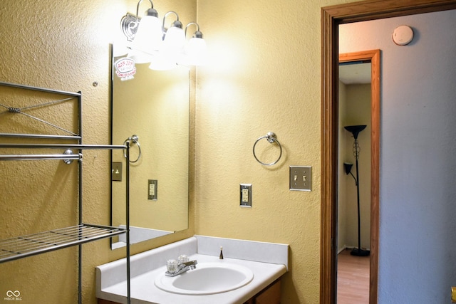 bathroom with vanity and a textured wall