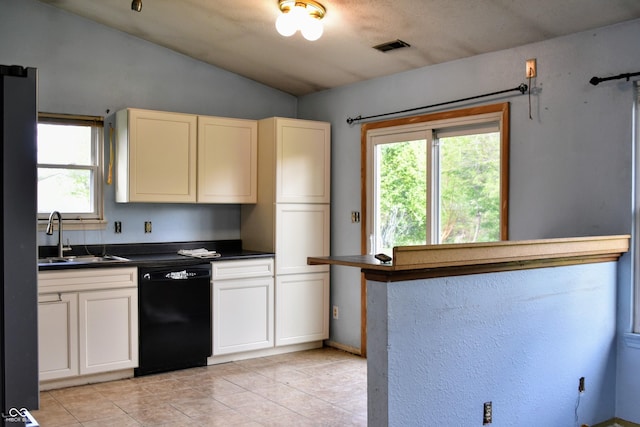 kitchen featuring lofted ceiling, dark countertops, black dishwasher, a sink, and light tile patterned floors