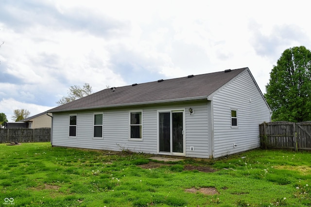 rear view of house with a lawn and fence private yard