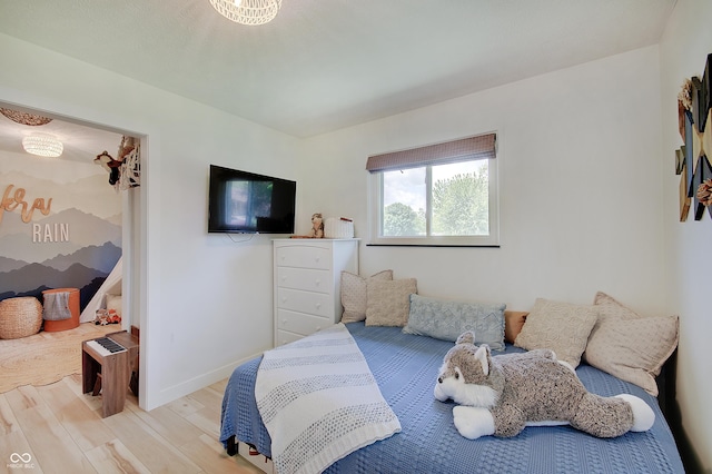 bedroom featuring wood finished floors and baseboards