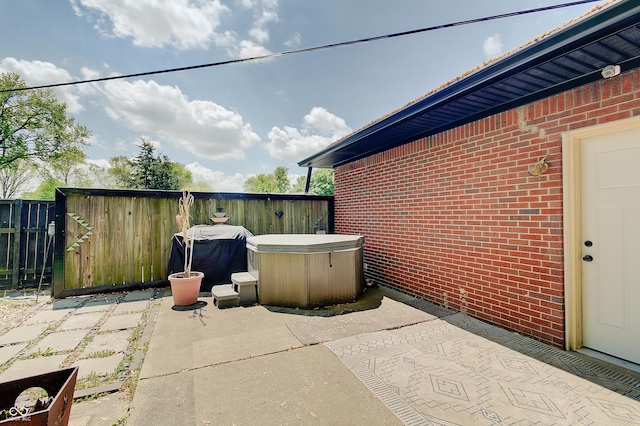 view of patio / terrace featuring a hot tub and fence