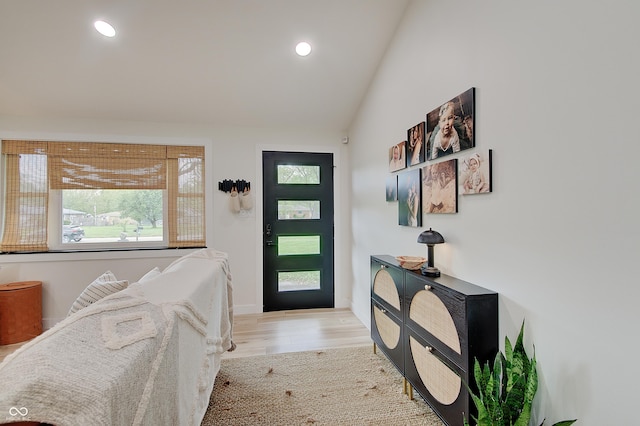 entryway with light wood finished floors, lofted ceiling, recessed lighting, and baseboards