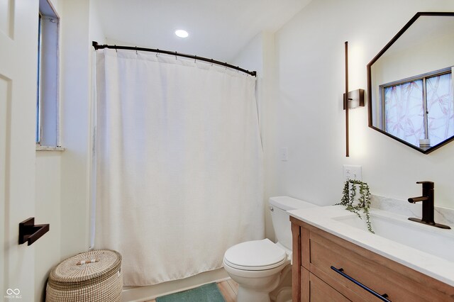bathroom featuring toilet, vanity, a shower with curtain, and recessed lighting