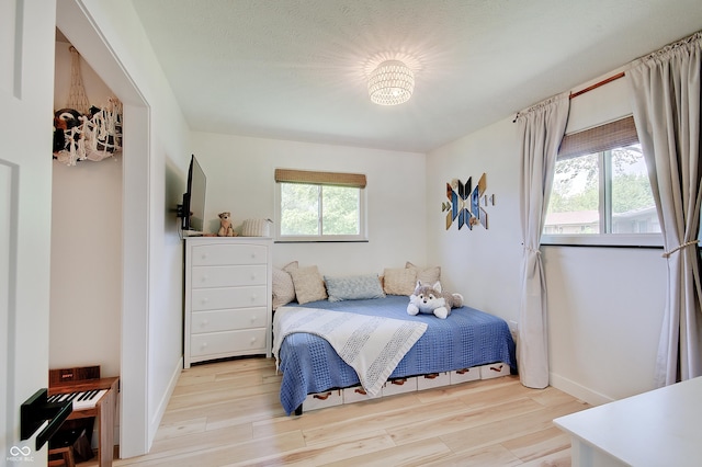 bedroom featuring wood finished floors and baseboards