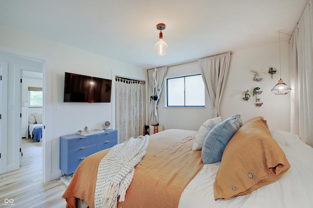 bedroom featuring multiple windows and light wood-style floors