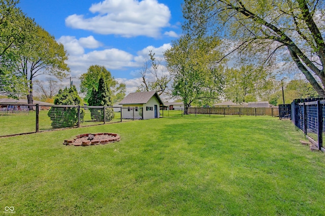 view of yard featuring an outdoor fire pit and an outbuilding