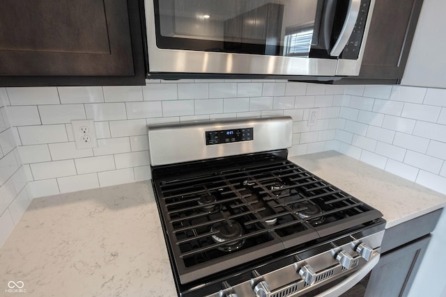 2628 Lamar Dr, Whitestown, IN 46075 - kitchen view of stainless steel appliances, tasteful backsplash, light stone countertops, and dark brown cabinetry