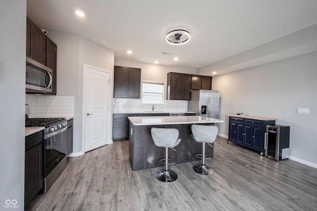 2628 Lamar Dr, Whitestown, IN 46075 - kitchen with stainless steel appliances, a sink, a kitchen island, a breakfast bar, and tasteful backsplash