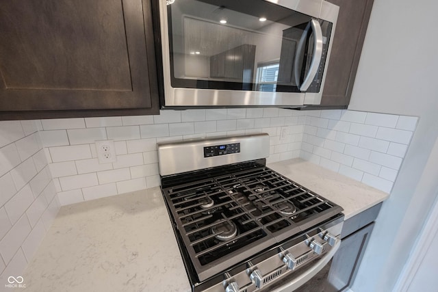 2628 Lamar Dr, Whitestown, IN 46075 - kitchen view of appliances with stainless steel finishes, dark brown cabinets, light stone countertops, and backsplash