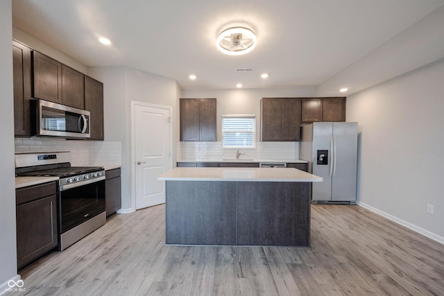 2628 Lamar Dr, Whitestown, IN 46075 - kitchen featuring appliances with stainless steel finishes, dark brown cabinets, light countertops, a kitchen island, and recessed lighting