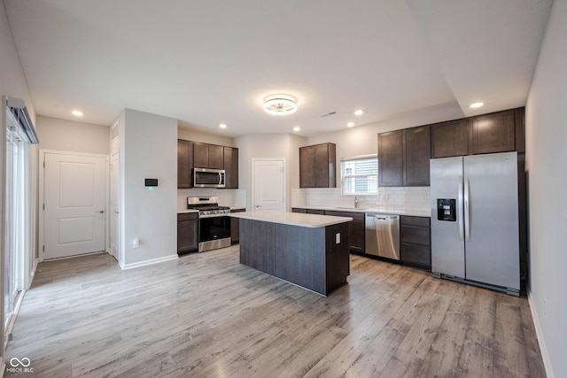 2628 Lamar Dr, Whitestown, IN 46075 - kitchen with appliances with stainless steel finishes, dark brown cabinets, light wood-style flooring, light countertops, and decorative backsplash