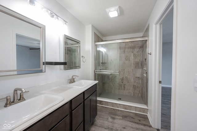 2628 Lamar Dr, Whitestown, IN 46075 - bathroom featuring a stall shower, wood finished floors, and double vanity