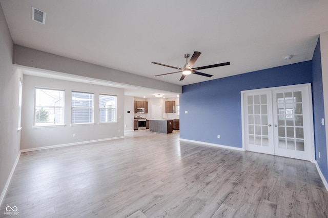 2628 Lamar Dr, Whitestown, IN 46075 - unfurnished living room featuring french doors, a ceiling fan, and light wood-style flooring
