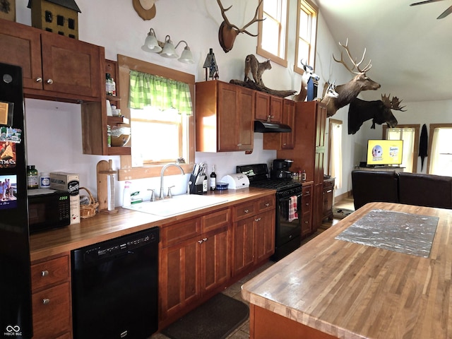 kitchen featuring black appliances, butcher block countertops, a sink, under cabinet range hood, and a ceiling fan