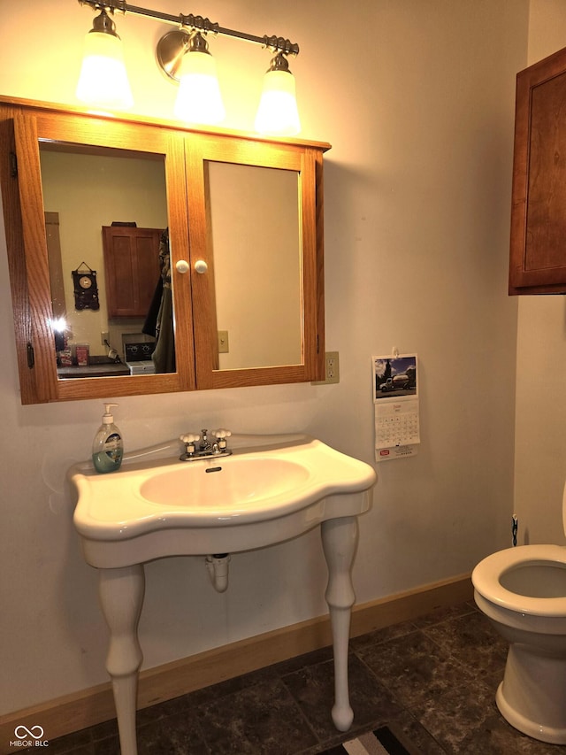 bathroom with baseboards and toilet