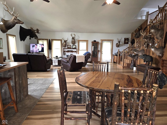 dining area featuring ceiling fan, stairs, and wood finished floors