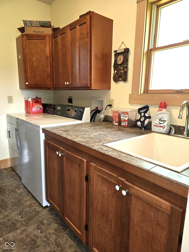 kitchen featuring washing machine and clothes dryer and a sink
