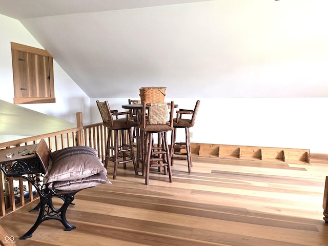 dining room with vaulted ceiling and wood finished floors