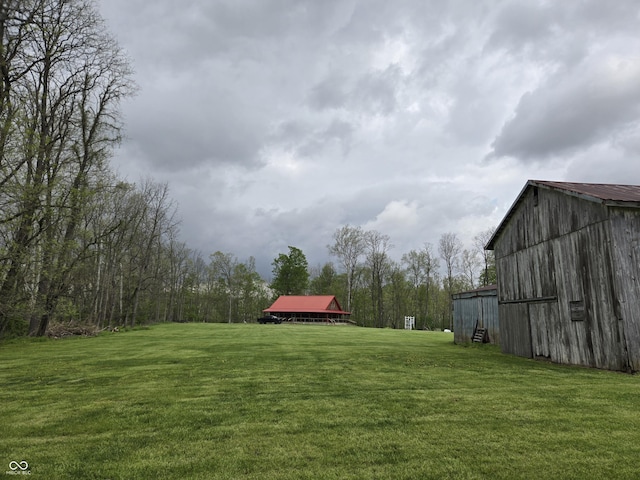 view of green lawn with an outdoor structure and an outbuilding
