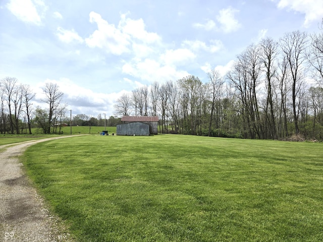 view of green lawn with an outbuilding and a barn