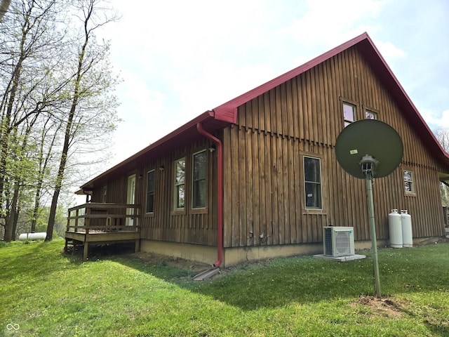 view of side of home with ac unit, a lawn, board and batten siding, and a wooden deck