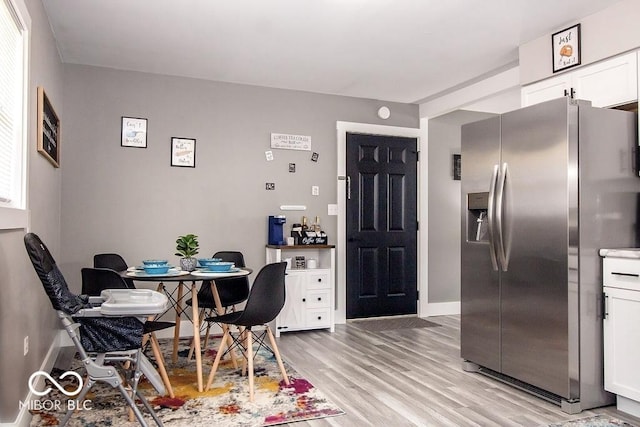dining room featuring baseboards and light wood-type flooring