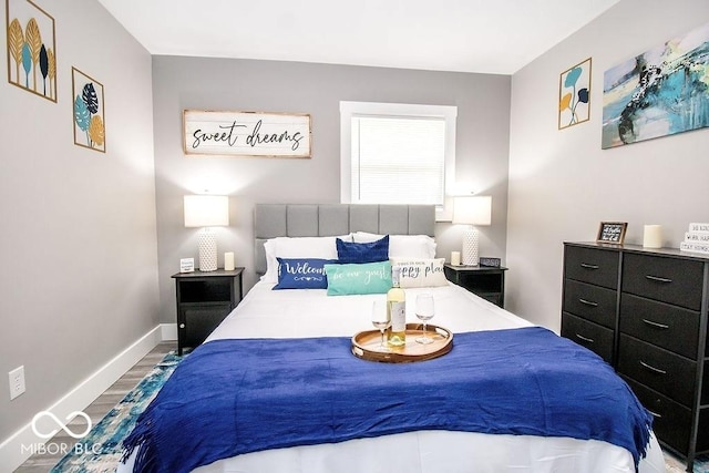 bedroom featuring baseboards and wood finished floors