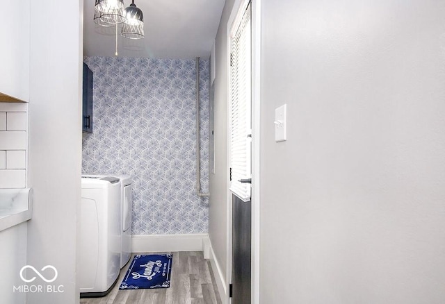 laundry area featuring cabinet space, baseboards, washing machine and dryer, and wood finished floors